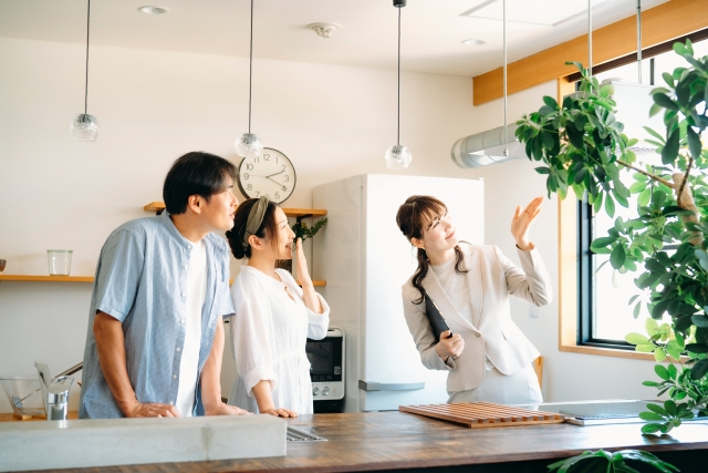 キッチンを案内する女性スタッフと夫婦