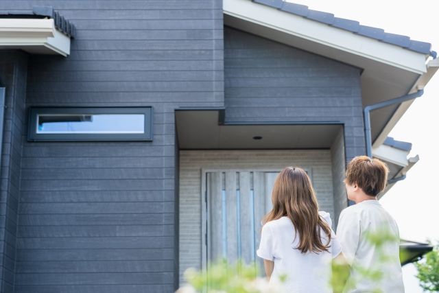 戸建てを見上げる家族